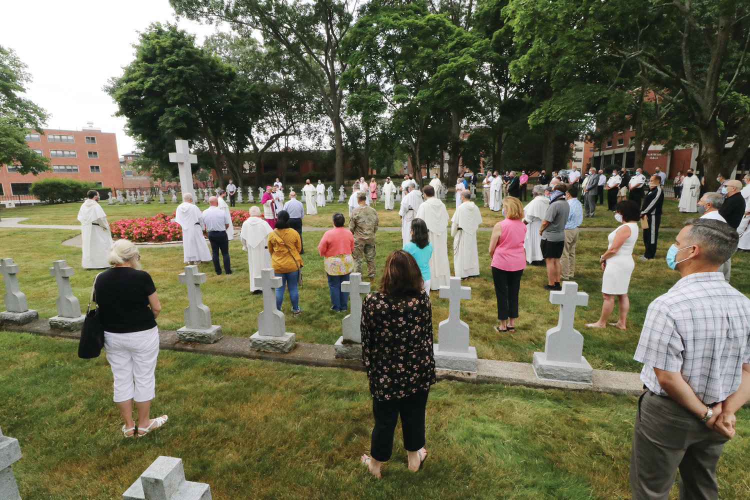 About 75 friars and members of the Providence College community gathered for the solemn ceremony during which Bishop Thomas J. Tobin blessed the grounds with holy water and incense — including the large granite crucifix standing in a garden of flowers at the center of the cemetery — as he offered prayers of consecration.